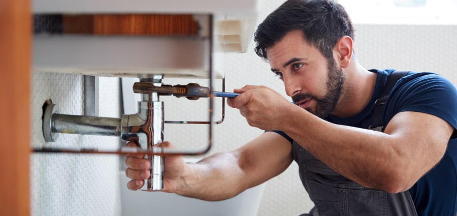 Traders man fixing sink